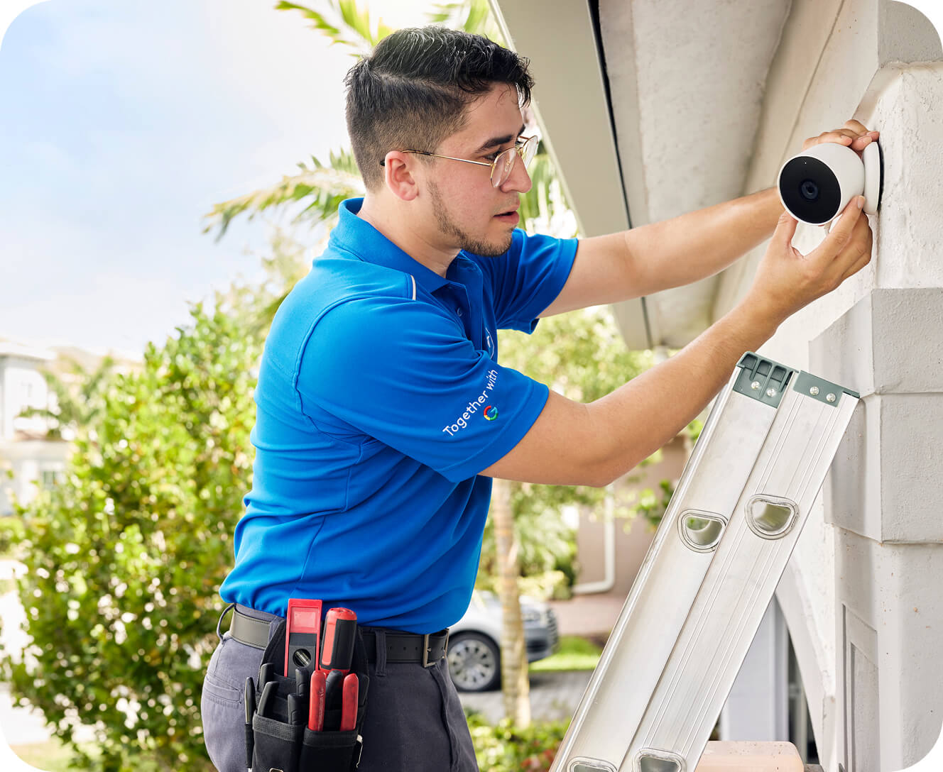 A man installs an ADT motion sensor inside a bright, modern home.